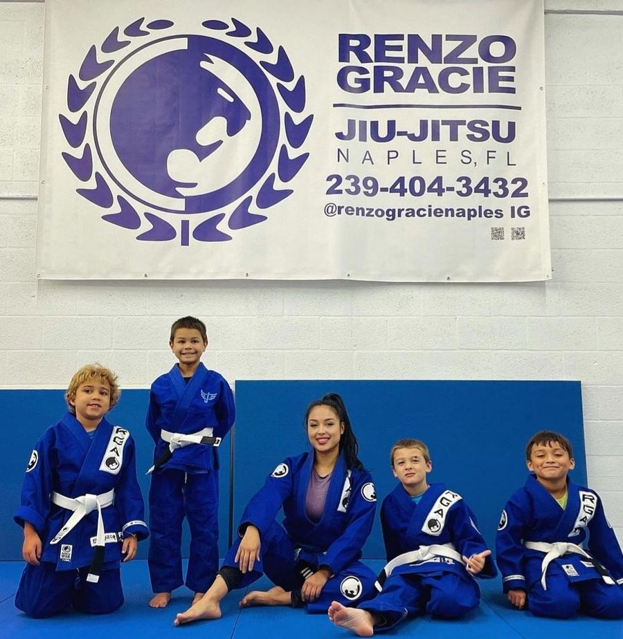 Kids in their gis in front of the Renzo Gracie Naples academy wall